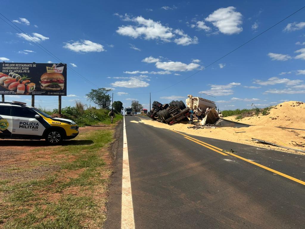 Caminhão carregado com ração tomba às margens da PR-082 em...
