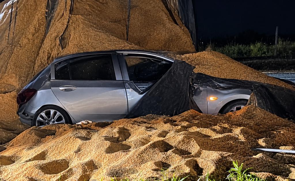 Carreta carregada de farelo de soja tomba sobre carro na BR-376, em...